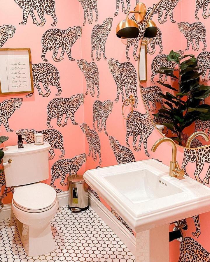 Pink leopard print wallpaper in a funky bathroom from @justjena with gold fixtures and retro hex tile floor.