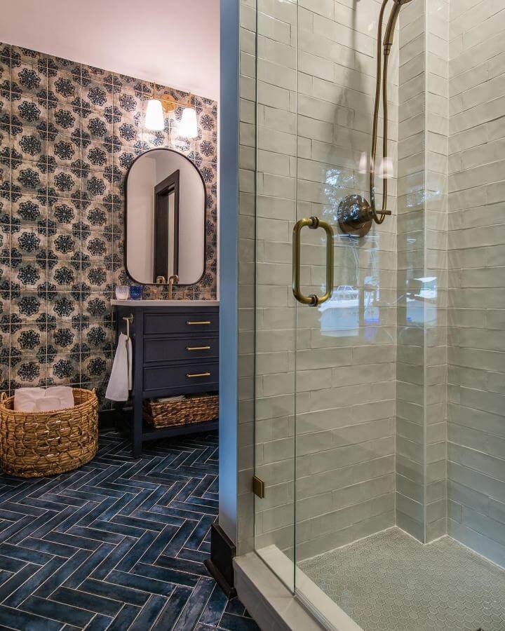 blue patterned tile wall and deep blue herringbone floor in bathroom by @saltmarshcontracting funky bathroom ideas with brass accents and navy vanity