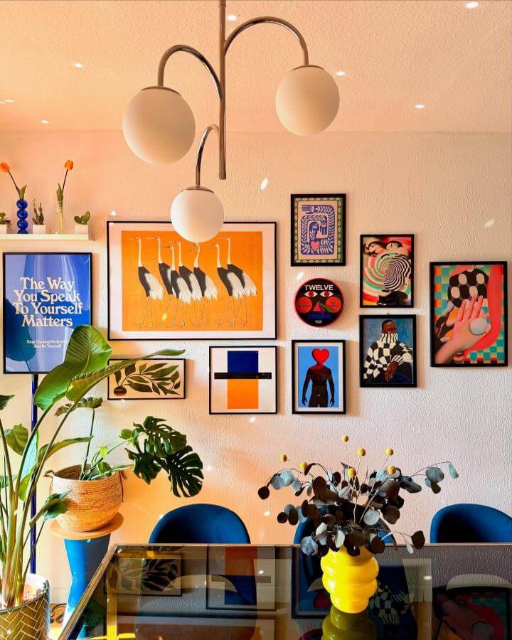 Eclectic vibrant wall art and typography with retro vinyl and plants from @casina.gialu brightens a cheerful eating space.