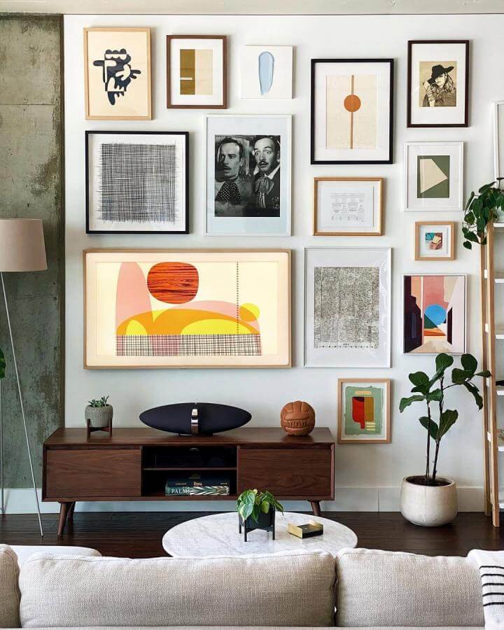 Warm eclectic gallery wall with mixed frames and abstract art by @donborsch. Vibrant yet cozy living room display.