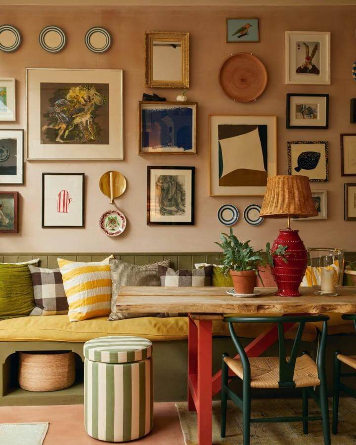 Warm eclectic gallery wall ideas from @aliciawaite_ featuring mixed frames, plates, and art on a beige wall with cozy seating below.