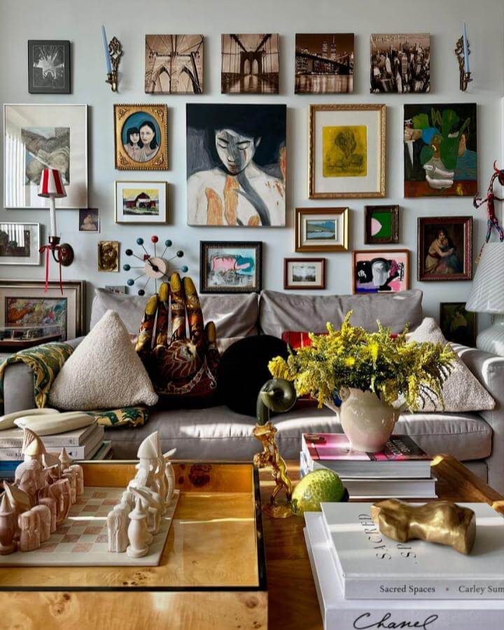 Eclectic mix of framed artworks and decorative objects on living room wall by @the_decor_studio showcasing layered personalized wall art.