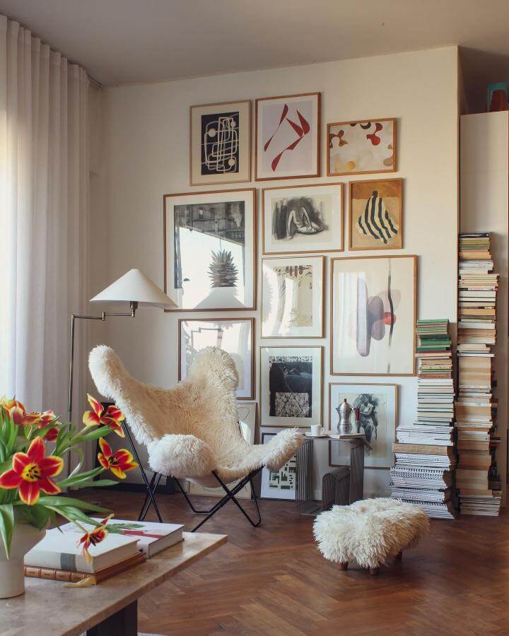 Cozy living area with mid-century style framed artwork in natural wood and soft neutral tones by @mittfunkis showing layered art styling.