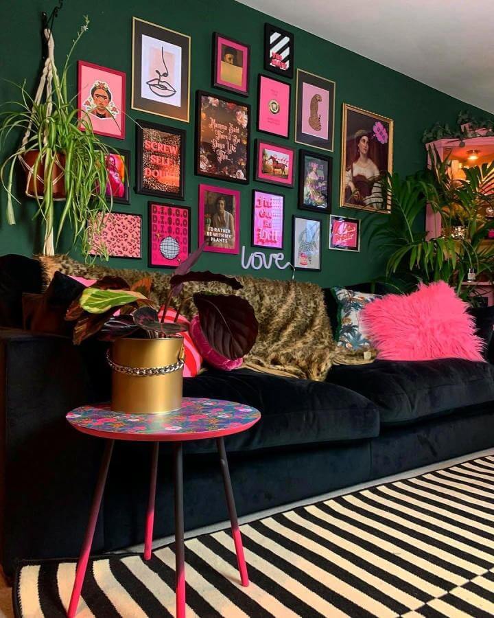 Pink and black eclectic gallery wall with neon sign and plants on dark green background from @lozincolour vibrant and lively living room space.