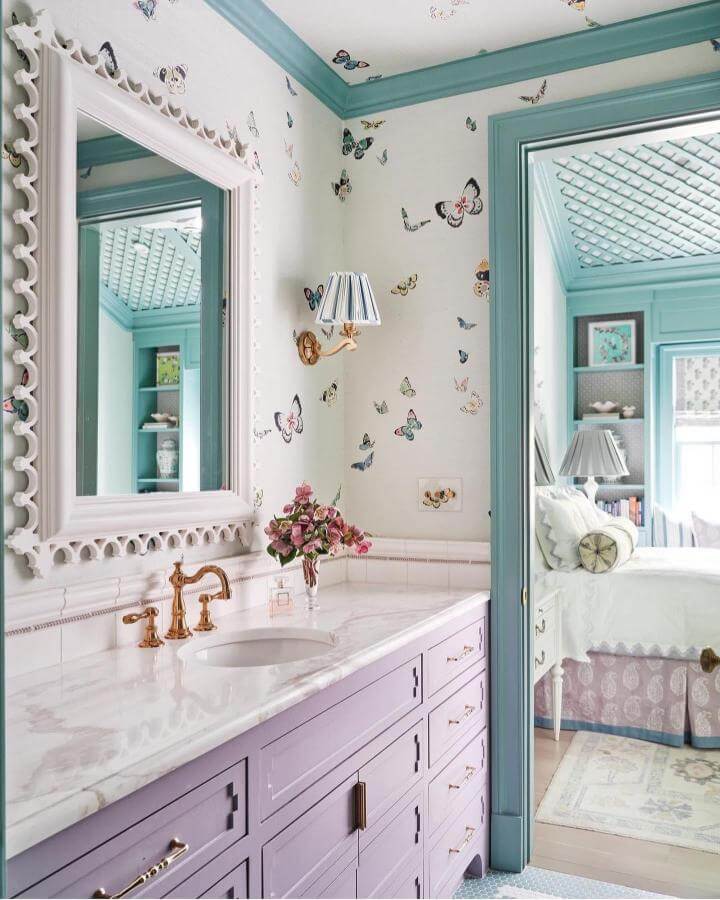 Soft lavender vanity, butterfly wallpaper, white marble countertop in girly bathroom ideas by @caitlinmcgauley. Whimsical and fresh style.