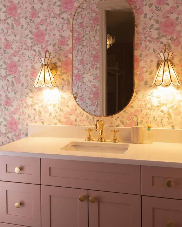Pink floral wallpaper and blush cabinetry bathroom vanity with gold fixtures from @cminteriordesigns. Soft, romantic girly bathroom ideas.
