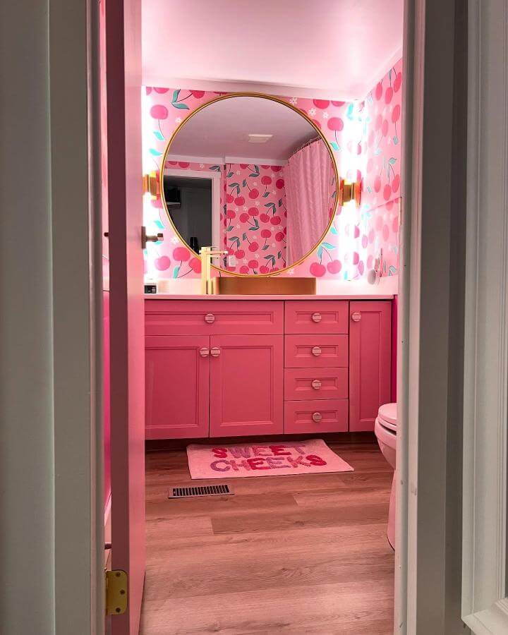 pink cabinetry and cherry wallpaper in a girly bathroom ideas from @refreshedandrefurbishedmb vibrant and youthful bathroom decor with gold accents