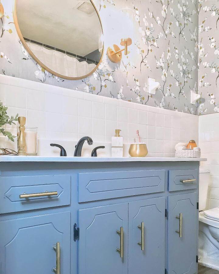Soft blue vanity and floral wallpaper in a girly bathroom ideas from @_obviouslyolive_ creating a cozy elegant space.