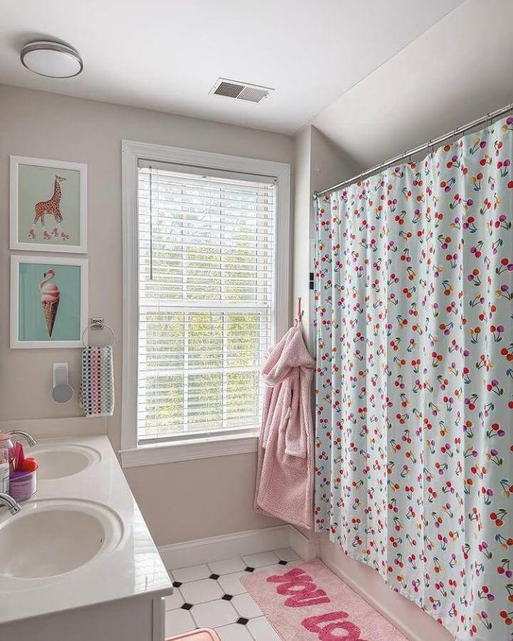 White shower curtain with colorful floral print in a girly bathroom ideas setting by @queenofthebeehive. Bright and playful decor with pink accents.