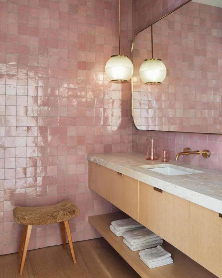 Shiny blush pink tile walls with wooden vanity and brass fixtures in girly bathroom ideas by @brigetteromanek bright and cozy space.