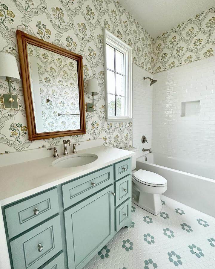 Soft mint cabinetry and floral wallpaper in a girly bathroom ideas setup by @canvasclaystudio with vintage and modern blends.