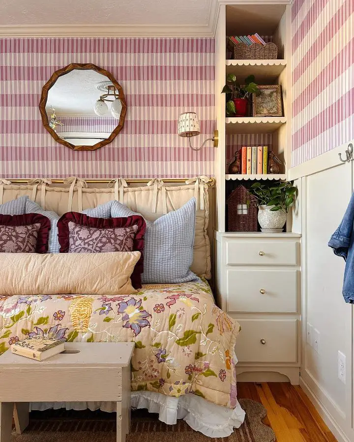 Pink striped wallpaper bedroom from @briebuilds. Cottage-style room with floral bedding and built-in storage shelves.