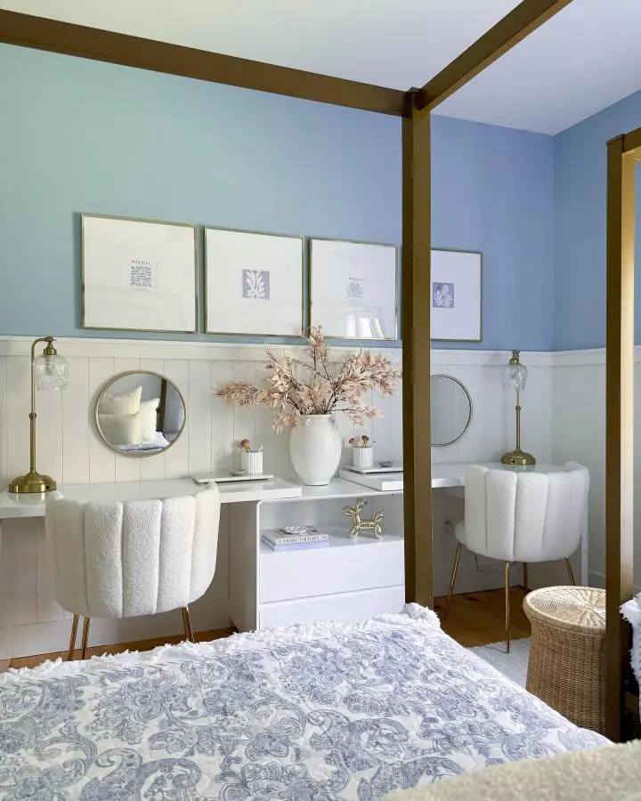 Brass canopy bed frame from @theverestplace. Blue walls with white wainscoting and built-in vanity area.