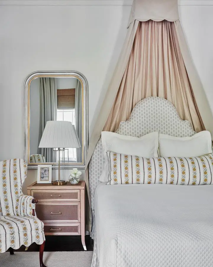 Blush pink canopy bed from @ashleygilbreathinteriordesign. Polka dot headboard with romantic flowing fabric draping.