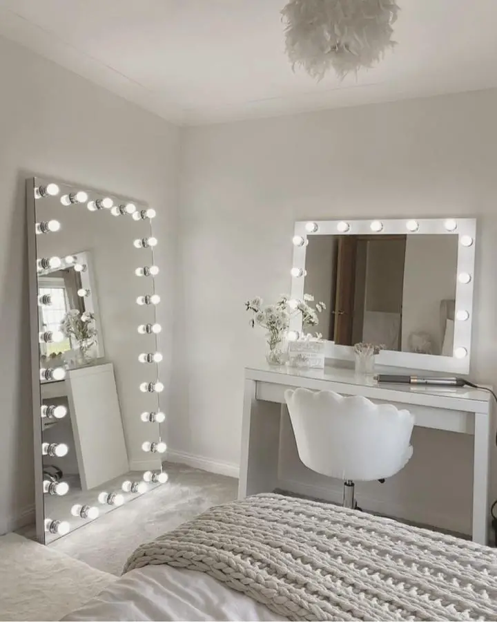 White framed Hollywood mirrors from @hollywoodmirrors with LED bulbs creating glamorous vanity setup in neutral bedroom.