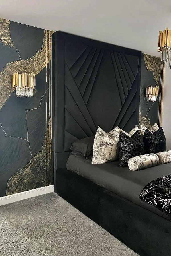 Emerald velvet headboard with geometric diamond pattern from @kikis_interiors. Gold crystal sconces frame marble wallpaper accent walls beautifully.