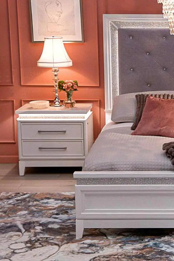 Silver-trimmed tufted headboard from @furniturerow with crystal button details and matching white nightstand furniture.
