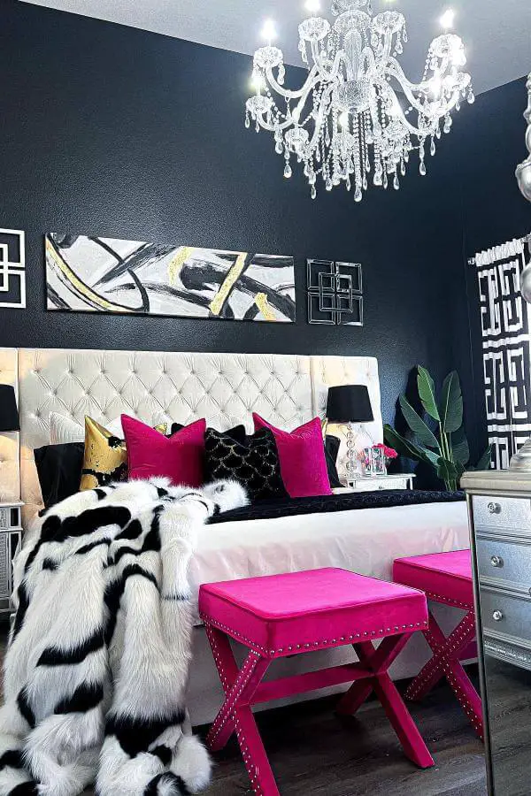 Dramatic crystal chandelier from @wendywittwerdesign. Navy walls with pink velvet bench and tufted white headboard.