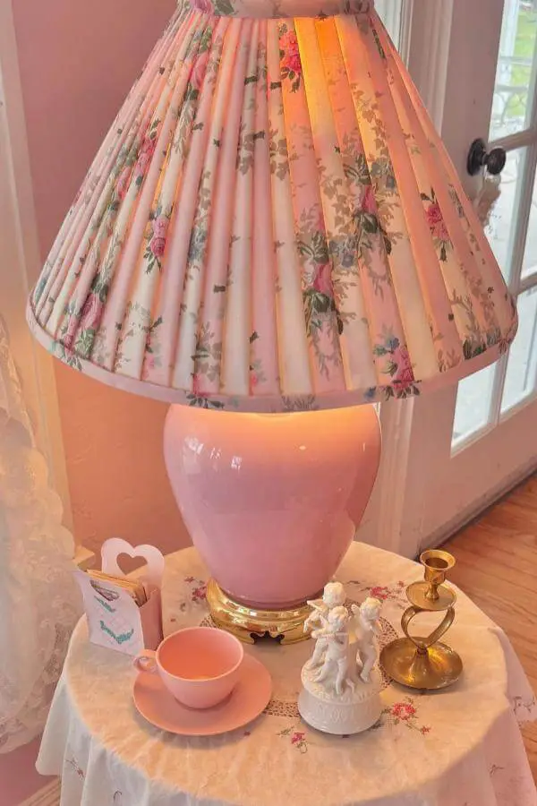 Pink ceramic table lamp with pleated floral shade showcasing grandmacore aesthetic decor from @hannahdahlross.