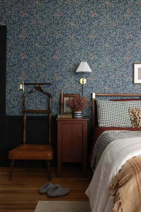 Mahogany valet chair from @our.argonne.home. Vintage bedroom furniture against sage floral wallpaper.