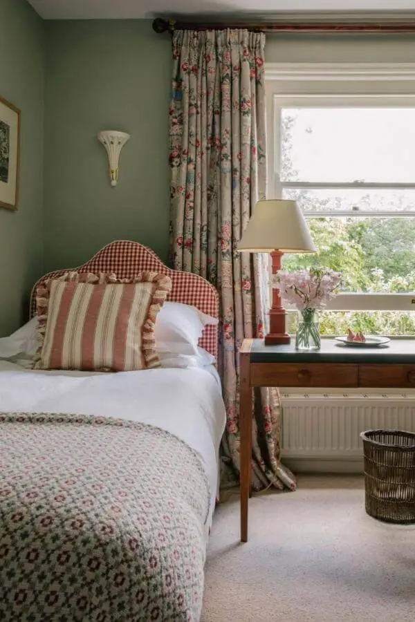 Red gingham upholstered headboard from @louiseroehome showcasing classic grandmacore bedroom ideas with layered vintage patterns.