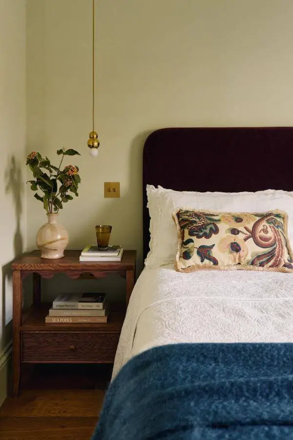Burgundy upholstered headboard from @emma__ainscough. Vintage-inspired bedroom with paisley cushion and cream bedding.