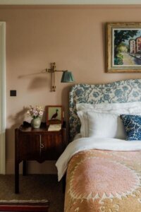 Adjustable brass wall sconce with green shade from @houseandgardenuk. Perfect vintage reading light above floral headboard.