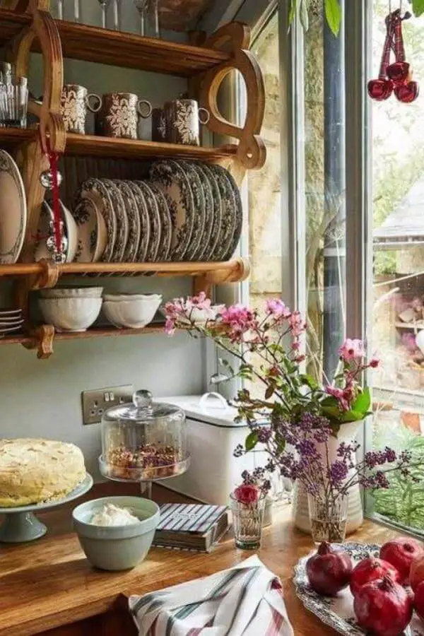 Curved wooden plate rack from @cutterbrooksshop displaying floral dishes, perfect for grandmacore kitchen ideas with vintage charm.