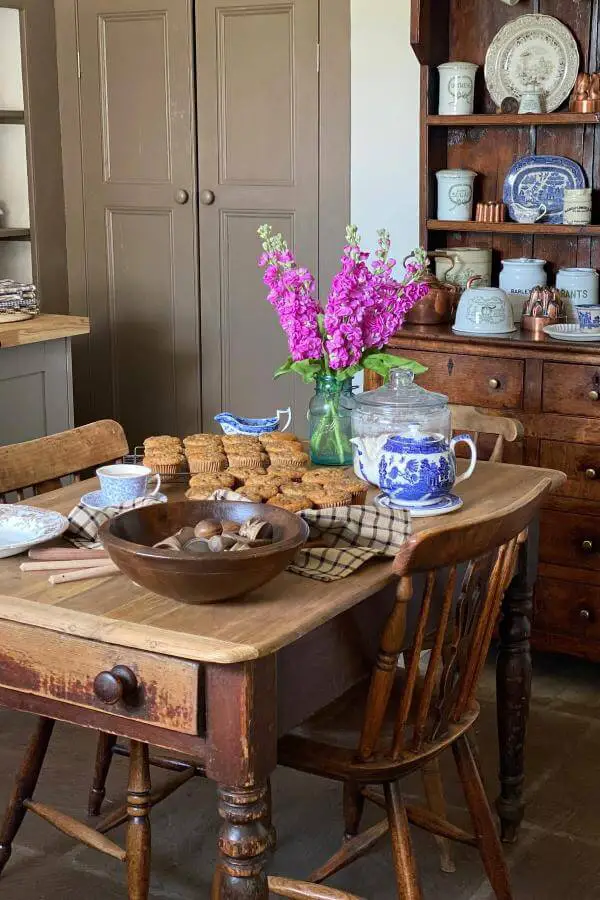 Blue and white transferware teapot from @rememberingtheoldways. Rustic wooden table with vintage china collection and fresh purple flowers.