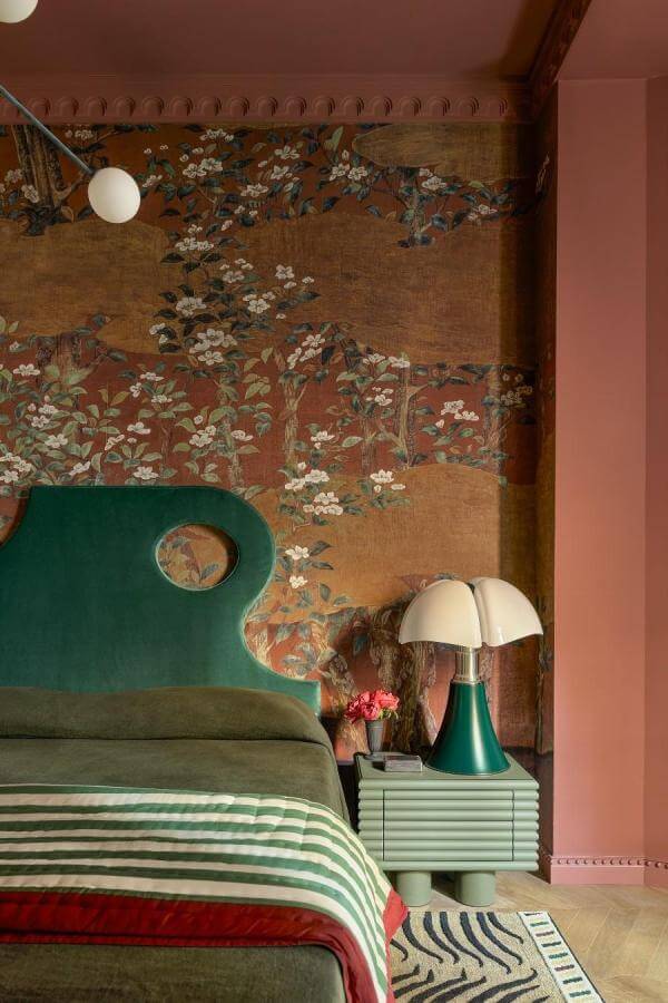 Whimsical floral mural feature wall from @gregnatale complements green and terracotta bedroom ideas with vibrant charm.