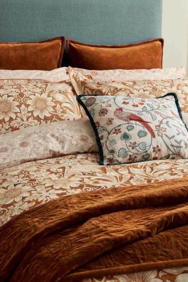 Whimsical floral and bird motif cushion charm from Bedeck. Ideal accent for green and terracotta bedroom schemes.