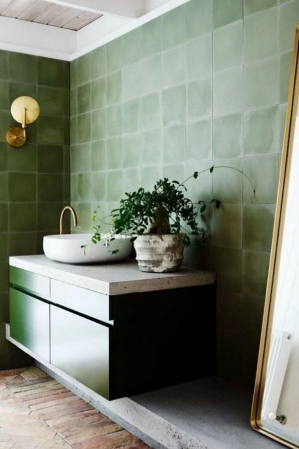 Elegant green bathroom with gleaming gold faucet accent; green bathroom ideas.