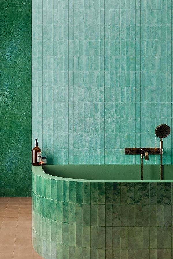 Curvaceous bathtub in tranquil green bathroom, showcasing elegant green bathroom ideas.