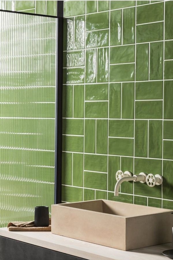 Green bathroom ideas: Herringbone pattern elevates serene, stylish, eco-friendly retreat.