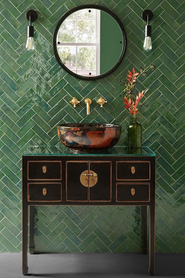 Bold herringbone tile wall featured in inspiring green bathroom ideas.