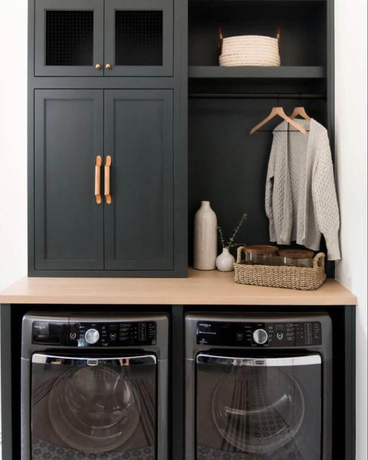 Deep matte green cabinetry in laundry room with wood countertop and leather handles by @fastcabinetdoors. Stylish yet functional green laundry room ideas.