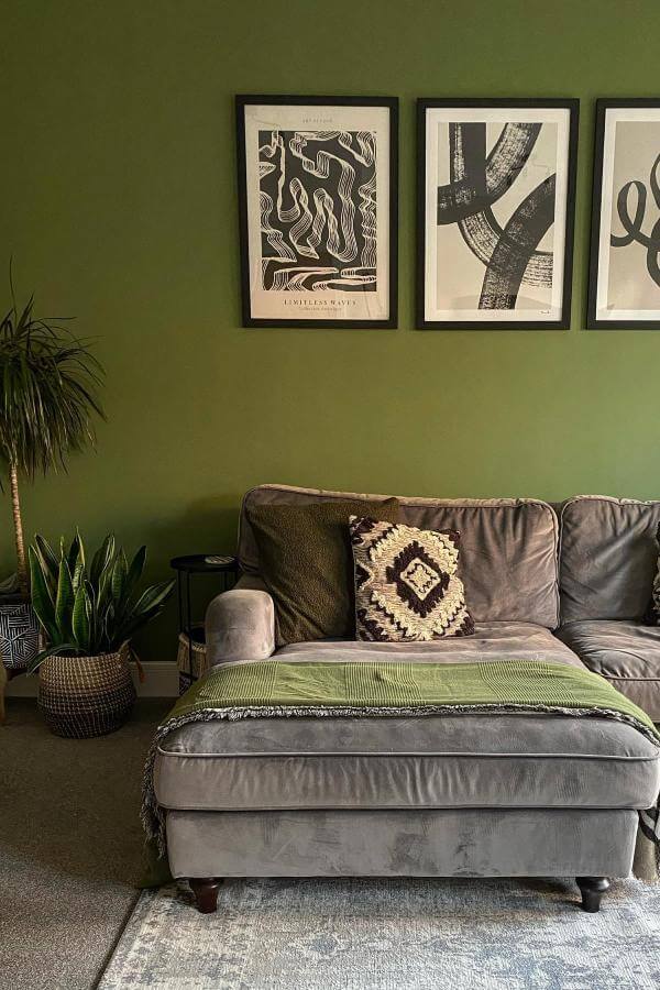 Bold geometric wall art with vibrant hues in green living room from @ashleigh.at.home, enhancing artistic flair and ambiance.