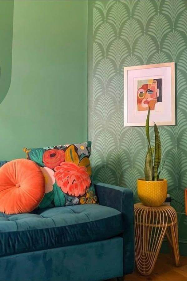 Colorful patterned throw pillows on sofa from @rainbowhomemonthly. Vibrant pops enhance green living room style.