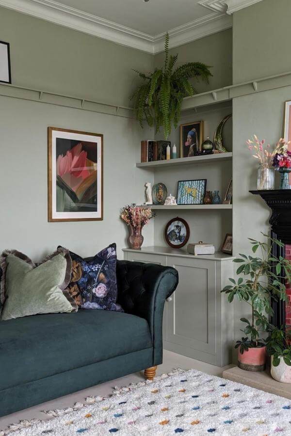 Warm wood open shelving from @ohmyedwardian showcasing statement decor for a stylish green living room.