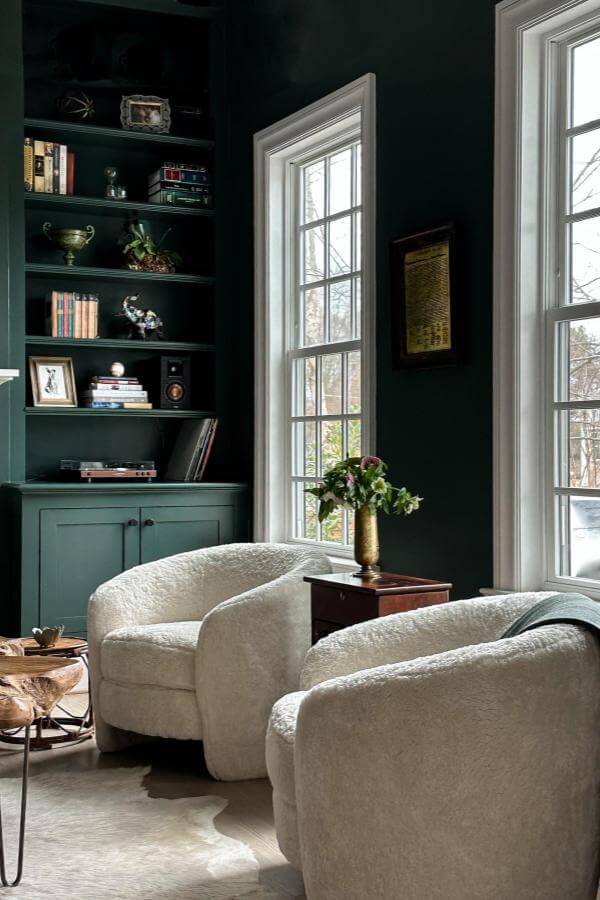 Deep green built-in bookshelves from @lizmearns add drama and depth to stylish green living room ideas.