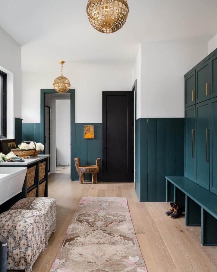Deep green paneled mudroom from @sarahshieldsphoto showcasing green mudroom ideas with built-in bench and brass accents.