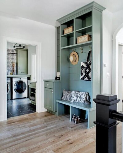 Sage green built-in mudroom bench and storage with shiplap and woven baskets from @memehillstudio showcasing practical, stylish entryway design.