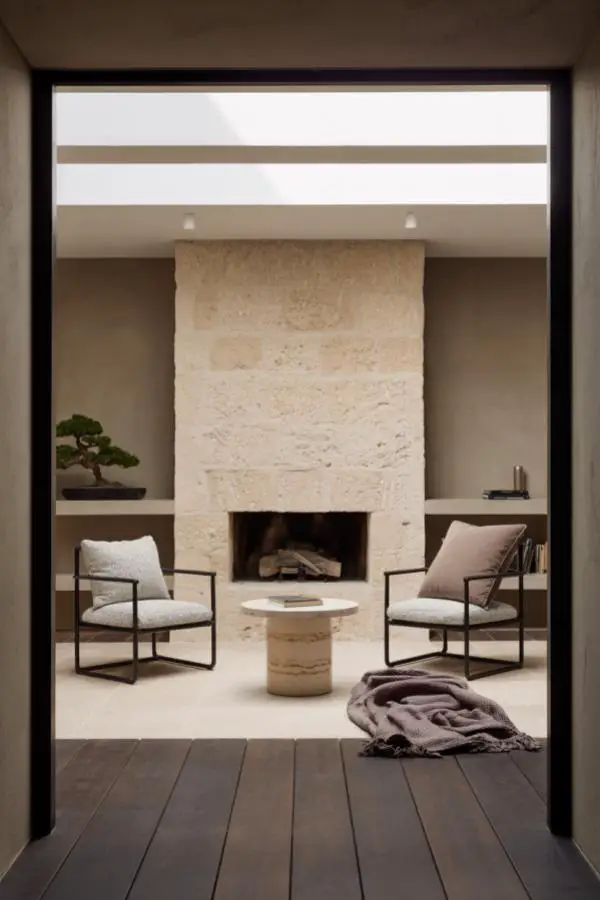 Natural stone fireplace with built-in shelving. Clean lines and neutral beige tones create sophisticated focal point.