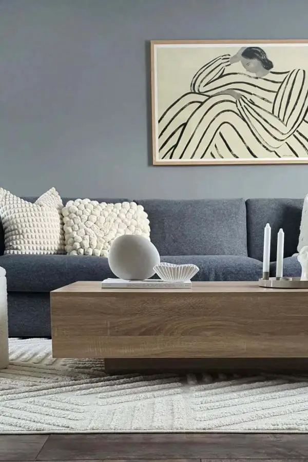 Modern grey sectional sofa from @homebydiana featuring textured cream pillows and wooden coffee table styling.