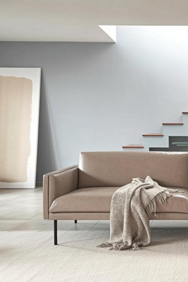 Floating wooden stairs and beige sofa in modern space. Clean architectural lines with warm wood accents.