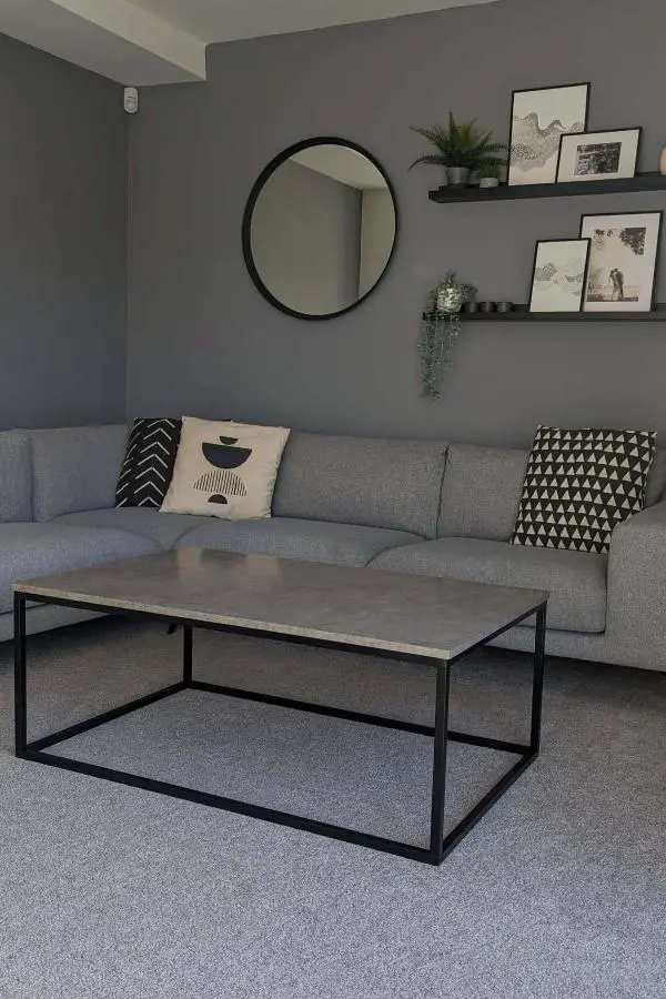 Minimalist living room with black floating shelves and neutral decor from @ourplainwhitebox. Clean lines and curated styling.