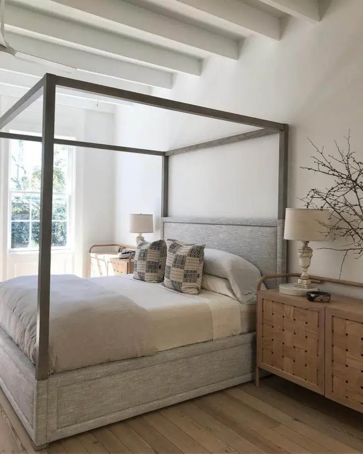 Natural wood canopy bed from @rethinkdesignstudio. White exposed ceiling beams create sophisticated architectural interest.