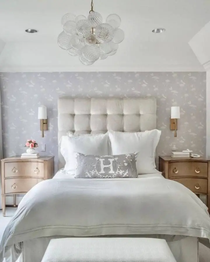 Transparent glass bubble chandelier from @lpearsondesign. Modern organic lighting fixture suspended above neutral tufted headboard.