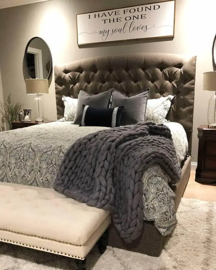 Luxurious gray tufted headboard bedroom from @jamiekuenzie. Chunky knit blanket and neutral bedding complete the sophisticated look.