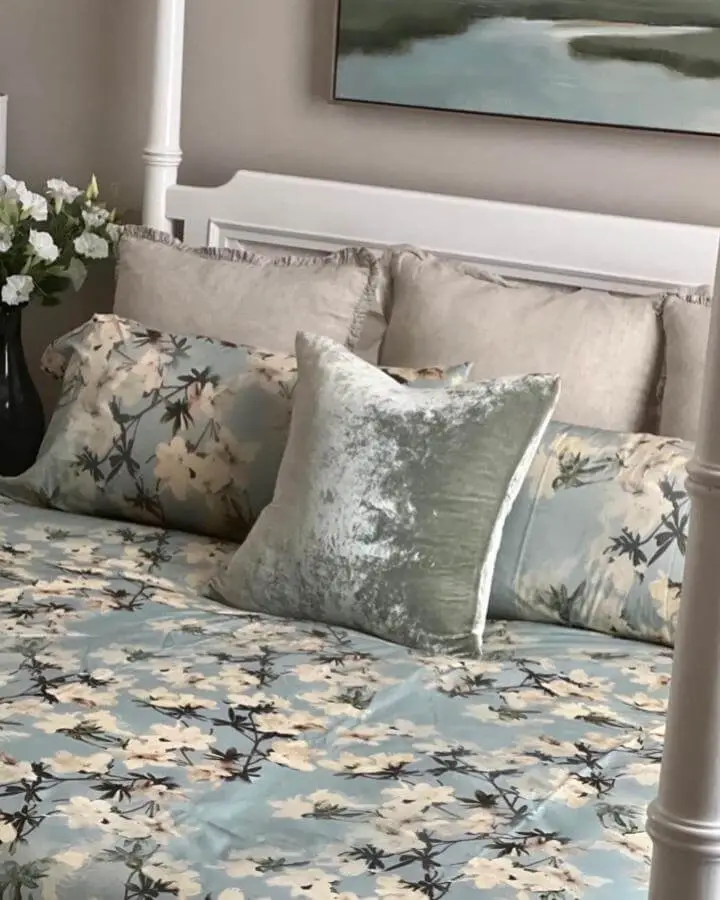 Sage green crushed velvet pillow from @twchome. Luxurious textured accent on floral bedding with white bed frame.